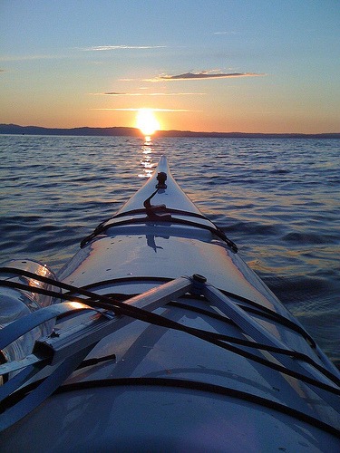 Kayaking into the sun / Cleaning the earth one beach at the time